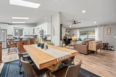 a kitchen and living room with a wooden table and chairs at Whispering Pines-Hot tub Getaway in Bailey