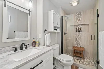 a bathroom with a sink and a toilet and a shower at Whispering Pines-Hot tub Getaway in Bailey