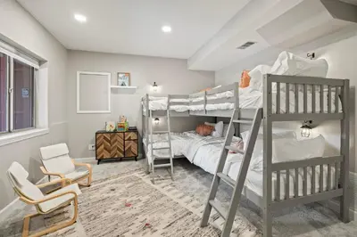 a bedroom with two bunk beds and a chair at Whispering Pines-Hot tub Getaway in Bailey