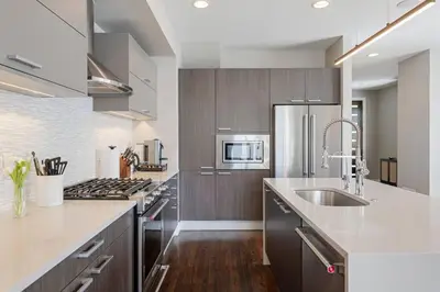 a kitchen with stainless steel appliances and wooden cabinets at Luxury Home: Monthly Rental House Near Denver in Englewood
