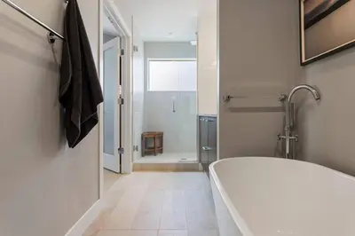 a white bathroom with a tub and a shower at Luxury Home: Monthly Rental House Near Denver in Englewood