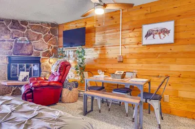 a living room with a table and a fireplace at 2 Mi to Granby Ranch Dog-Friendly Studio! in Granby