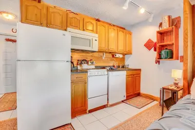 a kitchen with white appliances and wooden cabinets at 2 Mi to Granby Ranch Dog-Friendly Studio! in Granby