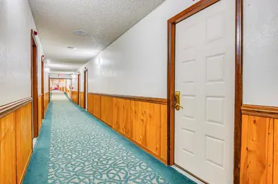 an empty corridor with a white door and a long aisle at 2 Mi to Granby Ranch Dog-Friendly Studio! in Granby