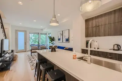 a kitchen with a sink and a living room at Upscale Townhome w/ Stunning Rooftop Views in Denver