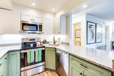a kitchen with green and white cabinets and a stove at Fraser Condo with Ski Shuttle and Resort Amenities! in Fraser