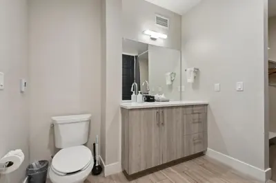 a bathroom with a toilet and a sink and a mirror at Graffiti & Skyline | RiNo Art Lofts in Denver
