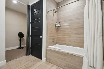 a bathroom with a tub and a shower at Graffiti & Skyline | RiNo Art Lofts in Denver