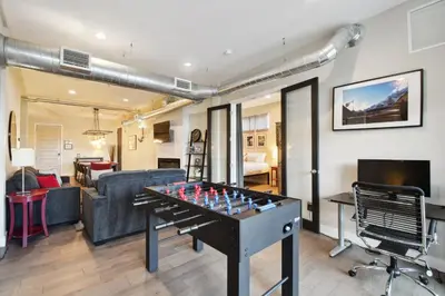 a living room with a ping pong table and a couch at Graffiti & Skyline | RiNo Art Lofts in Denver