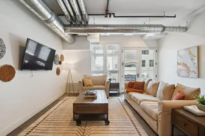 a living room with a couch and a table at Brushed & Bold | RiNo Art Lofts in Denver