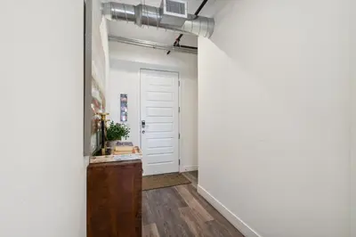 a hallway with a white wall and a white door at Brushed & Bold | RiNo Art Lofts in Denver