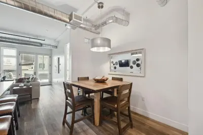 a dining room and living room with a table and chairs at Brushed & Bold | RiNo Art Lofts in Denver