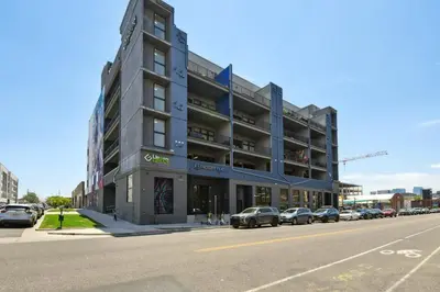 a building on a street with cars parked in front of it at Brushed & Bold | RiNo Art Lofts in Denver