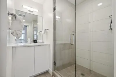 a white bathroom with a shower and a sink at Cowboy Muse | RiNo Art Lofts in Denver