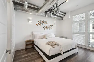 a white bedroom with a large bed and white walls at Cowboy Muse | RiNo Art Lofts in Denver
