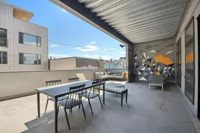a patio with a table and chairs on a building at Cowboy Muse | RiNo Art Lofts in Denver