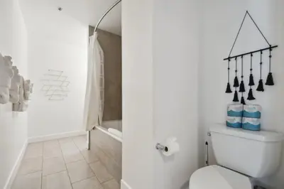 a white bathroom with a toilet and a shower at Cowboy Muse | RiNo Art Lofts in Denver