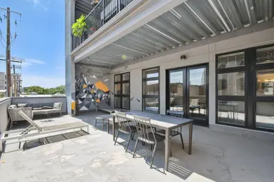 a patio with tables and chairs on a building at Cowboy Muse | RiNo Art Lofts in Denver