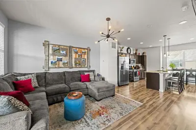 a living room with a couch and a kitchen at Uptown Avenue - Broomfield in Broomfield