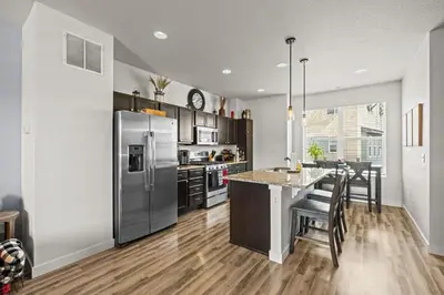 a kitchen with a stainless steel refrigerator and a counter at Uptown Avenue - Broomfield in Broomfield