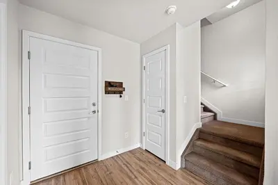 a hallway with stairs and a white door at Uptown Avenue - Broomfield in Broomfield