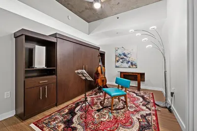 a living room with a blue chair and a rug at Spire - Unit 1810 in Denver