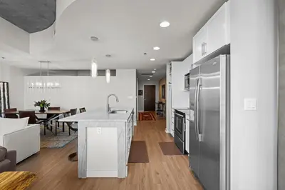 a kitchen and living room with a stainless steel refrigerator at Spire - Unit 1810 in Denver