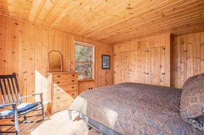 a bedroom with a bed and a chair in a cabin at Chasm Cabin -- 20-NCD0048 cabin in Estes Park