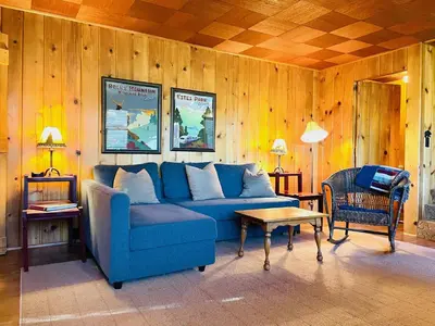 a living room with a blue couch and a table at Chasm Cabin -- 20-NCD0048 cabin in Estes Park