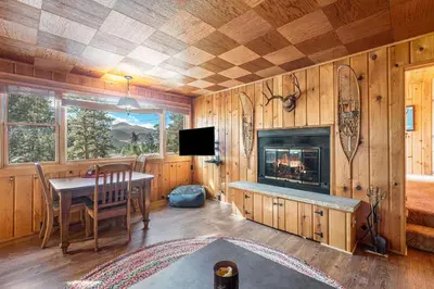a dining room with a table and a fireplace at Chasm Cabin -- 20-NCD0048 cabin in Estes Park