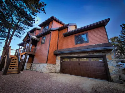 a wooden house with a garage and a staircase at Eldondale -- 22-ZONE3272 home in Estes Park