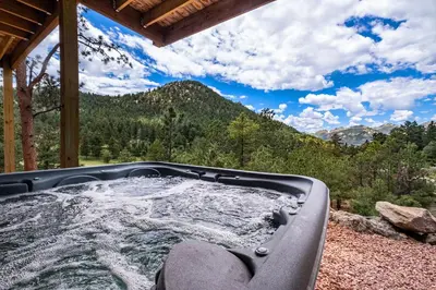 a hot tub with a view of the mountains at Eldondale -- 22-ZONE3272 home in Estes Park