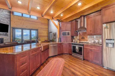 a large kitchen with wooden cabinets and wooden floors at Eldondale -- 22-ZONE3272 home in Estes Park