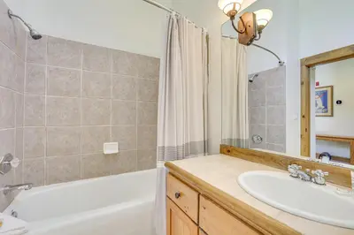 a bathroom with a tub and a sink and a mirror at Keystone Ski House Gem Walk to River Run Gondola! in Keystone