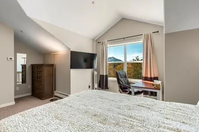 a bedroom with a bed and a desk and a window at Alpine Ridge A25 by Great Western Lodging in Dillon