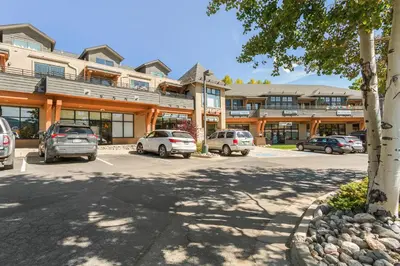 a parking lot with cars parked in front of a building at Alpine Ridge A25 by Great Western Lodging in Dillon