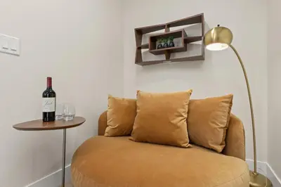a room with a couch with a bottle of wine and a lamp at Contemporary Gem - Rooftop Deck & Private Hot Tub! in Fort Collins
