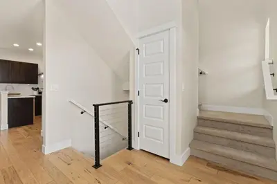 a hallway with a door and stairs in a house at Contemporary Gem - Rooftop Deck & Private Hot Tub! in Fort Collins
