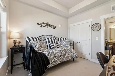a bedroom with a bed and a clock on the wall at Serene Retreat with Hot Tub, Sauna, Pool & Gym in Windsor
