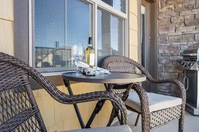 a table with two chairs and a bottle of wine at Serene Retreat with Hot Tub, Sauna, Pool & Gym in Windsor