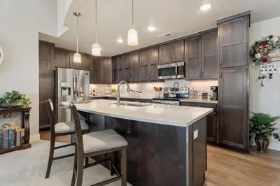 a kitchen with wooden cabinets and a kitchen island with a sink at Serene Retreat with Hot Tub, Sauna, Pool & Gym in Windsor