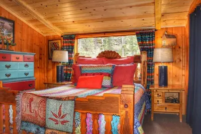 a bedroom with a bed in a log cabin at Pine Haven Resort in Estes Park