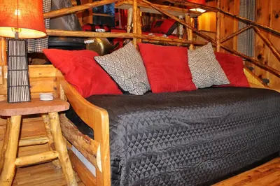 a black couch with red pillows in a room at Pine Haven Resort in Estes Park