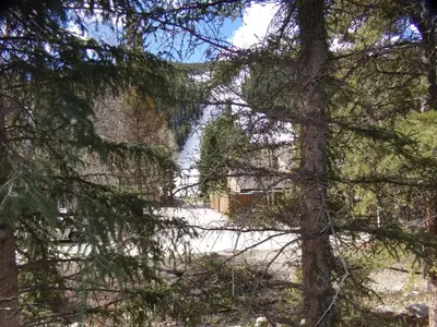 a building through the branches of a tree at Chateau DuMont Oversized 2 Bed 2 Bath CDMR in Keystone