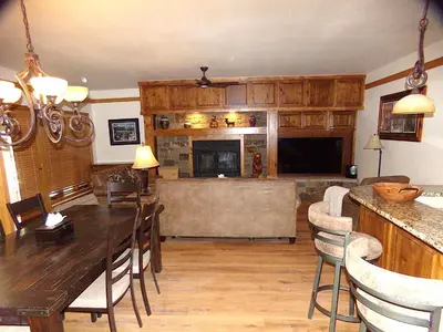 a living room with a table and a fireplace at Chateau DuMont Oversized 2 Bed 2 Bath CDMR in Keystone