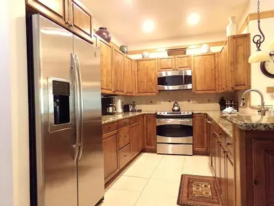 a kitchen with wooden cabinets and a stainless steel refrigerator at Chateau DuMont Oversized 2 Bed 2 Bath CDMR in Keystone