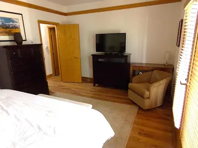 a bedroom with a bed and a tv and a chair at Chateau DuMont Oversized 2 Bed 2 Bath CDMR in Keystone