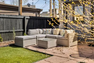 a wicker couch sitting on a patio in a yard at Updated Central LoHi Home - Large Yard - 32nd Ave in Denver