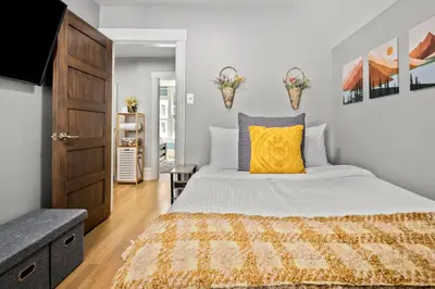 a bedroom with a large bed with a yellow pillow at Updated Central LoHi Home - Large Yard - 32nd Ave in Denver