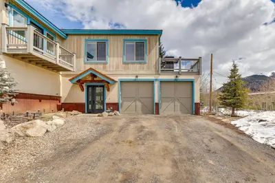 a house with two garage doors on a dirt road at Walk to Slopes Home with Hot Tub in Keystone in Keystone